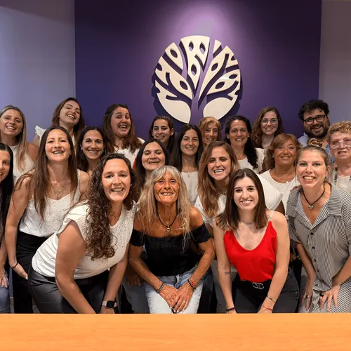 El equipo completo del estudio reunido frente al logo del árbol en la recepción