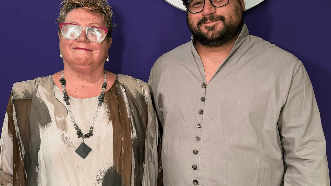Ana Delrío y Bernardo Fernández, socios del estudio, frente al logo del árbol en la recepción